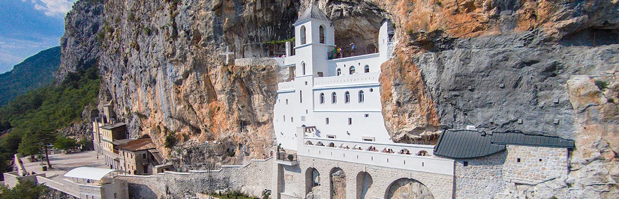 Posetite Manastir Ostrog u Crnoj Gori: duhovno utočište uklesano u stenu, poznato po isceliteljskim moštima svetog Vasilija i prelepim pogledima.