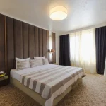 Delux dvokrevetna soba u Grand Hotelu Bansko predstavlja idealan izbor za parove i male porodice koje žele uživati u vrhunskom komforu. Ove sobe, površine oko 35 m², pružaju prostran i elegantan prostor za opuštanje i odmor. Svaka soba opremljena je francuskim ležajem ili dva singl kreveta, što omogućava fleksibilnost u smeštaju.